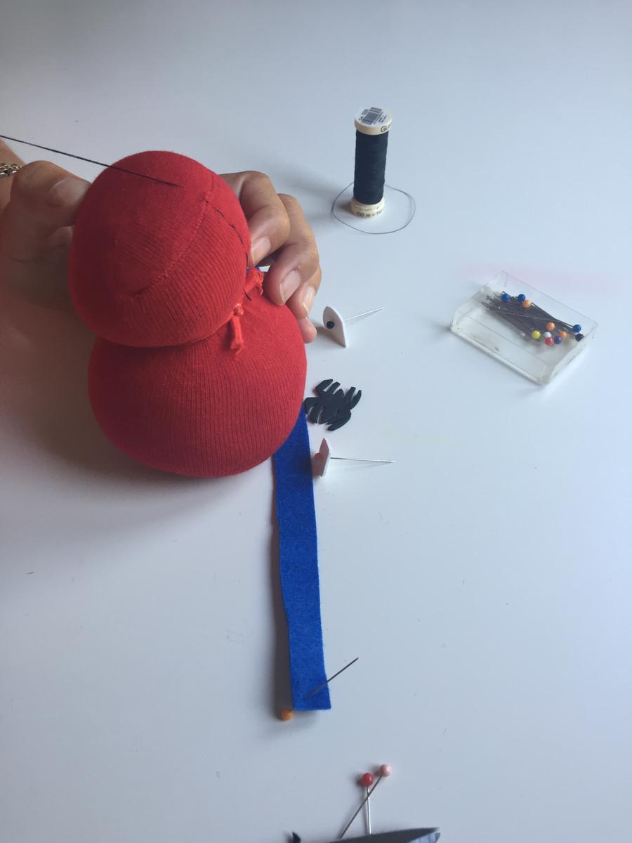 para hacer la araña de la vestimenta lo hacemos cosiendo con hilo negro