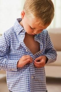 West New York, New Jersey, USA --- Caucasian boy buttoning his shirt --- Image by © KidStock/Blend Images/Corbis