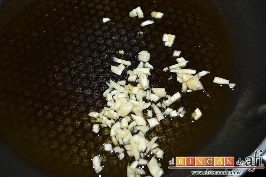 Habas con jamón, poner a rehogar el ajo troceado en una sartén con un buen chorro de aceite de oliva