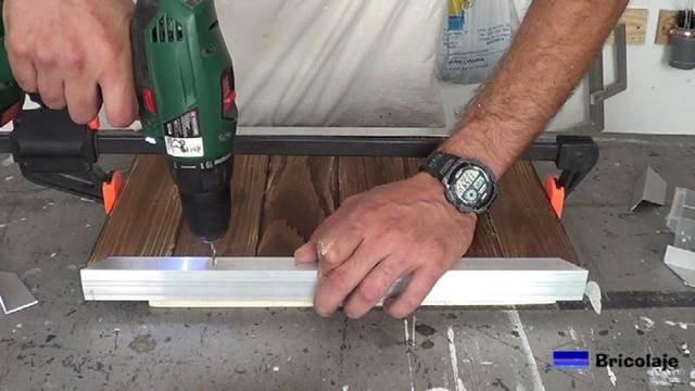 taladrando el ángulo de aluminio para sujetar la madera de palé