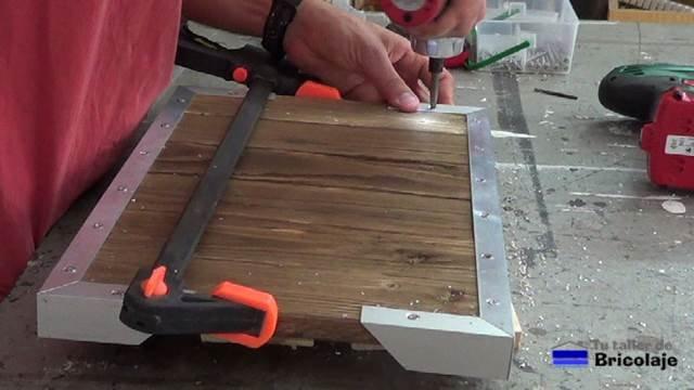 atornillando el ángulo a la madera de palé