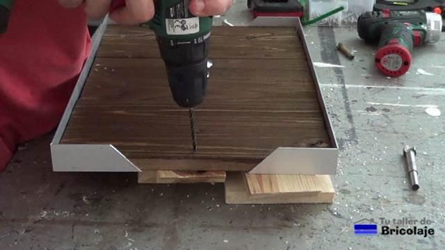 perforando para colocar los pomos para sujetar la bandeja de comida