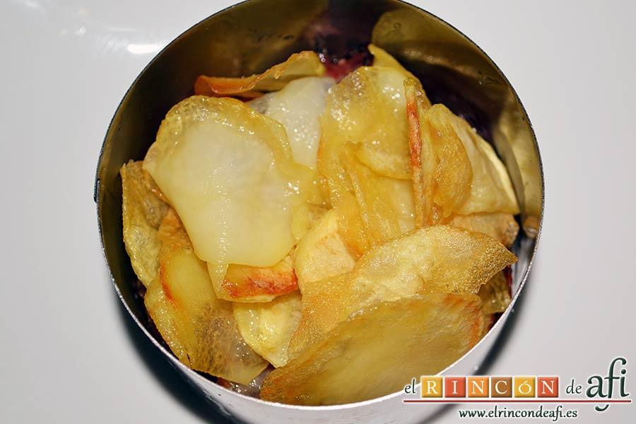 Papas fritas, huevos fritos, bacon y cebollas, ponemos una buena cama de papas