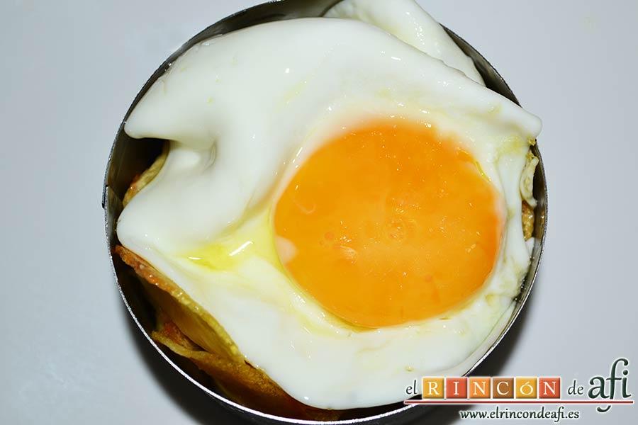 Papas fritas, huevos fritos, bacon y cebollas, colocar el huevo sobre las papas