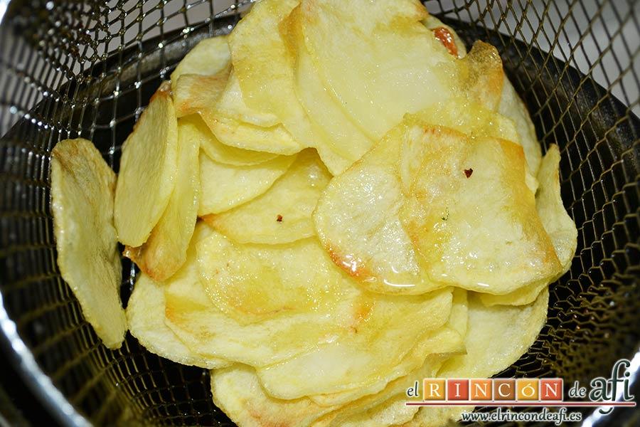 Papas fritas, huevos fritos, bacon y cebollas, freír las papas en una freidora