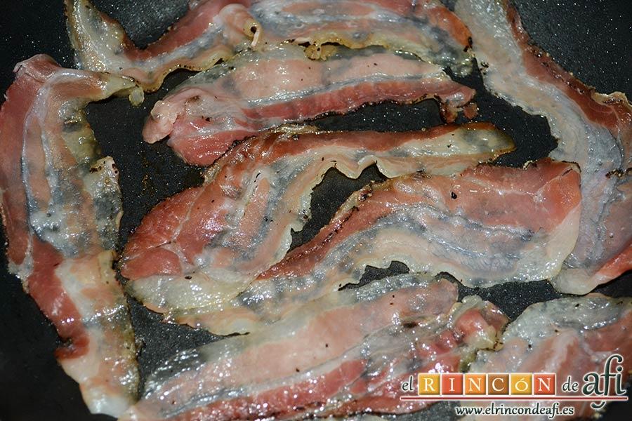 Papas fritas, huevos fritos, bacon y cebollas, dorar el bacon en una sartén sin nada de aceite