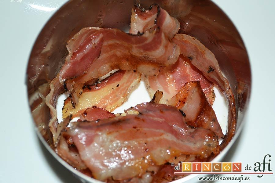 Papas fritas, huevos fritos, bacon y cebollas, en un aro colocamos alrededor las lonchas de bacon