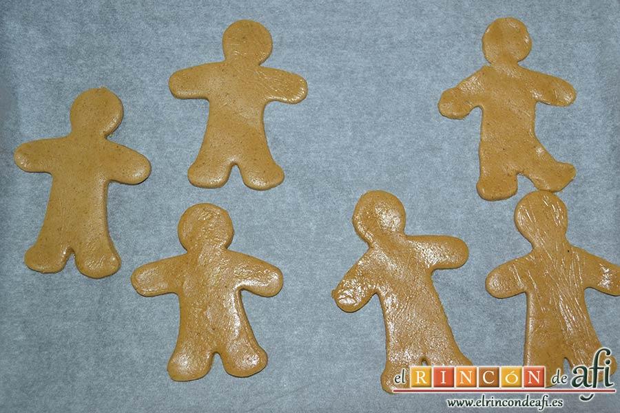 Galletas de jengibre y canela, ponemos papel de horno sobre una bandeja de hornear y colocamos las figuras encima