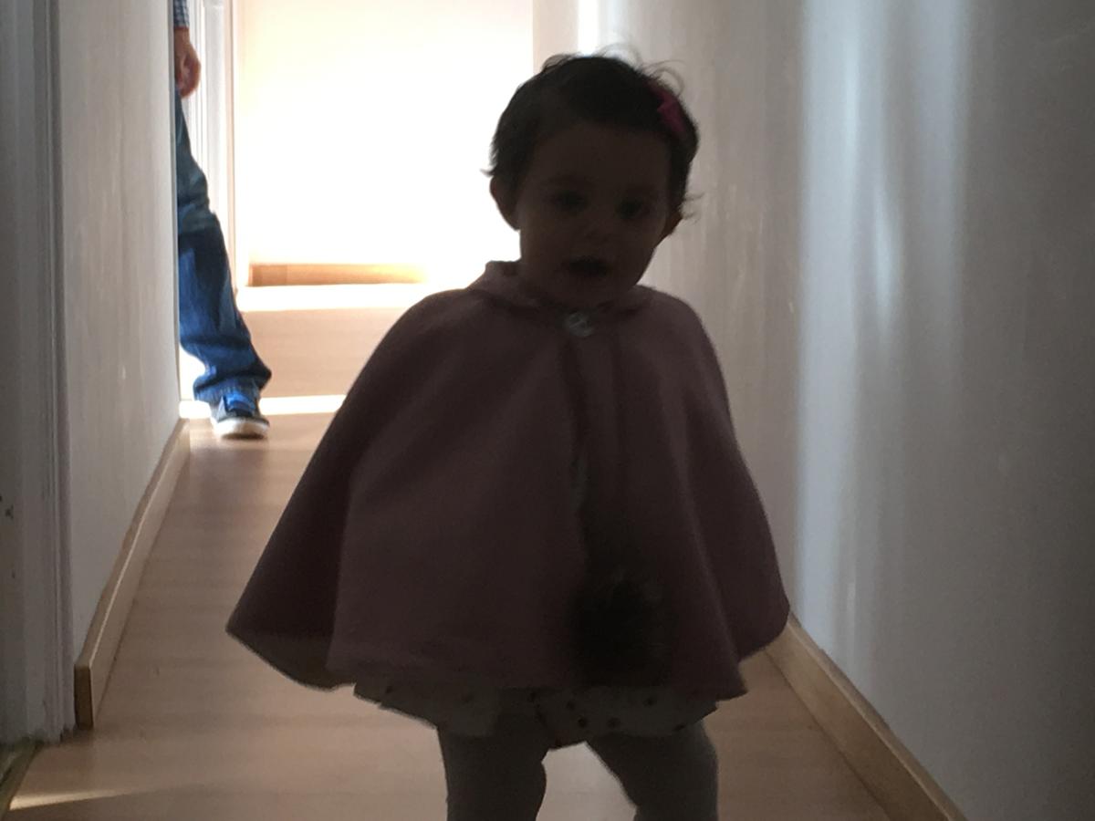 La bebe corre con su capa
