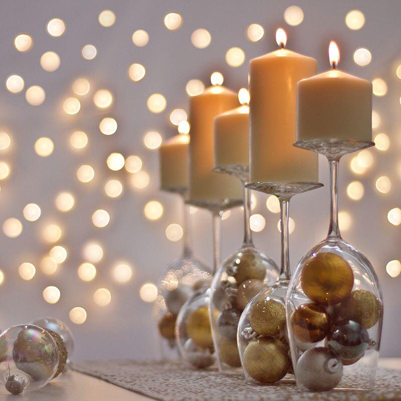 mesa de nochevieja decorada con copas, velas y bolas de navidad