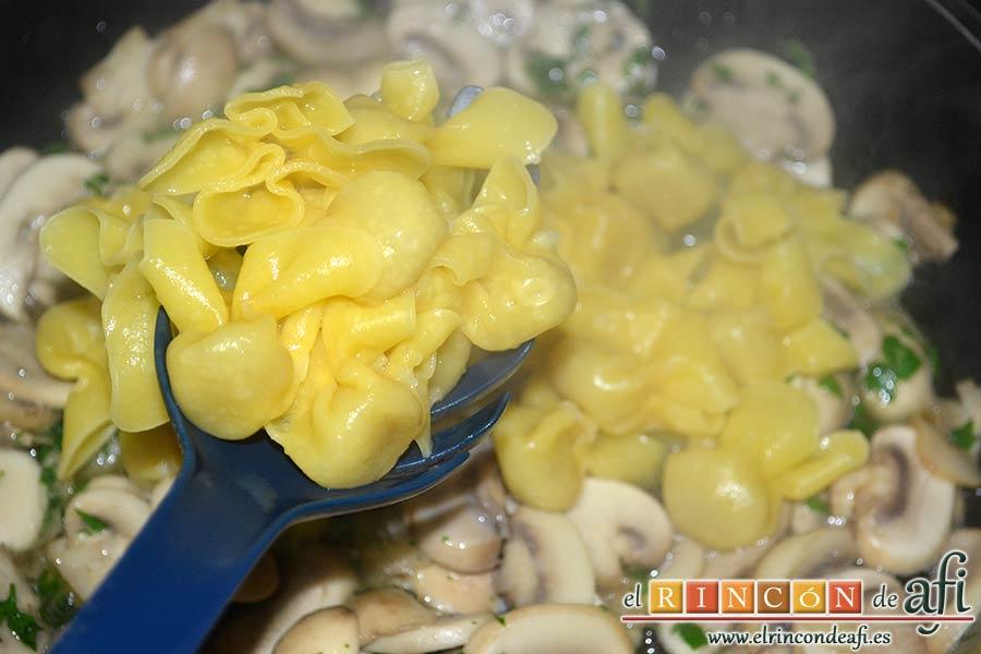Pasta fresca con champiñones al ajillo, escurrir la pasta y volcarla sobre los champiñones