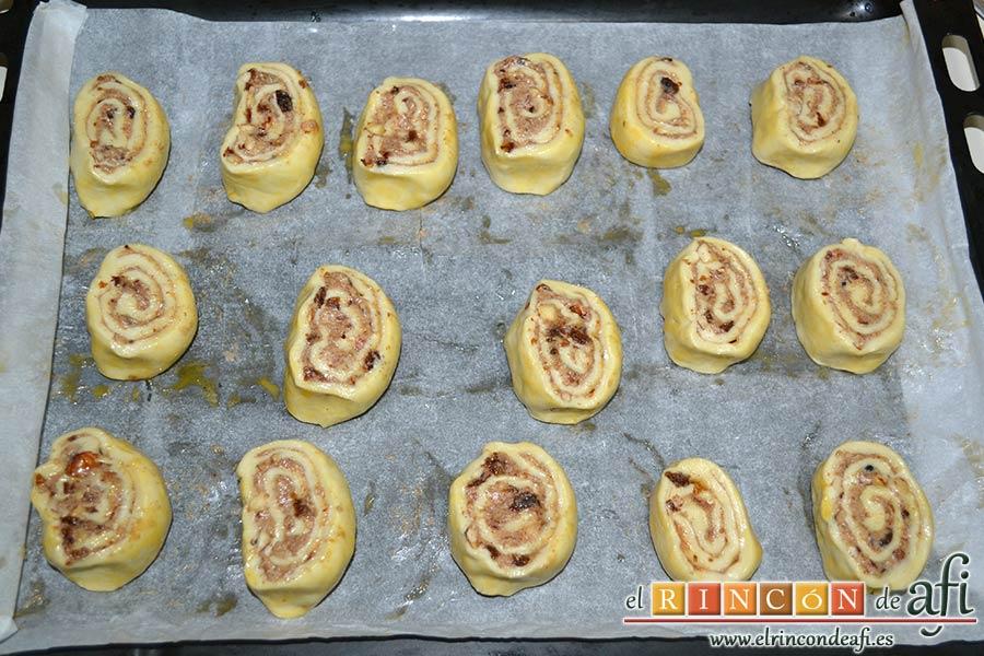 Caracolas de canela, pintar con el huevo batido la parte de abajo y las disponemos en una bandeja para horno con papel de horno