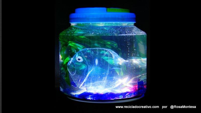 Pez hecho con una botella de plástico, dentro de una pecera con botellas de PET