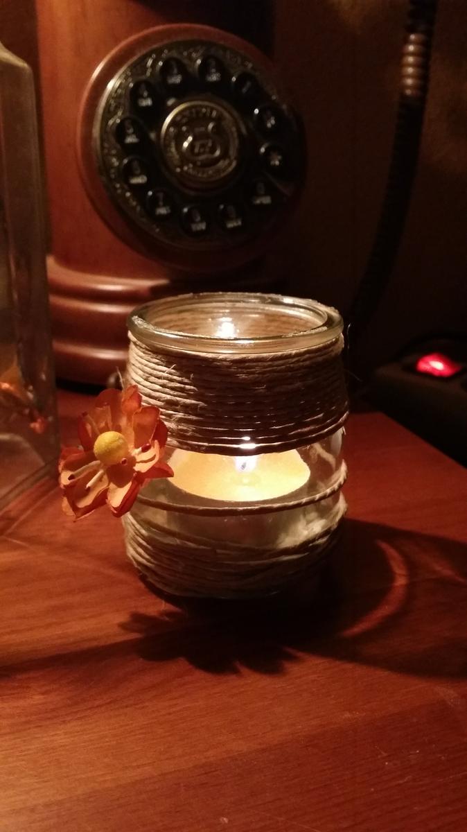 Portavelas con aire rústico, con cuerda y una flor de tela