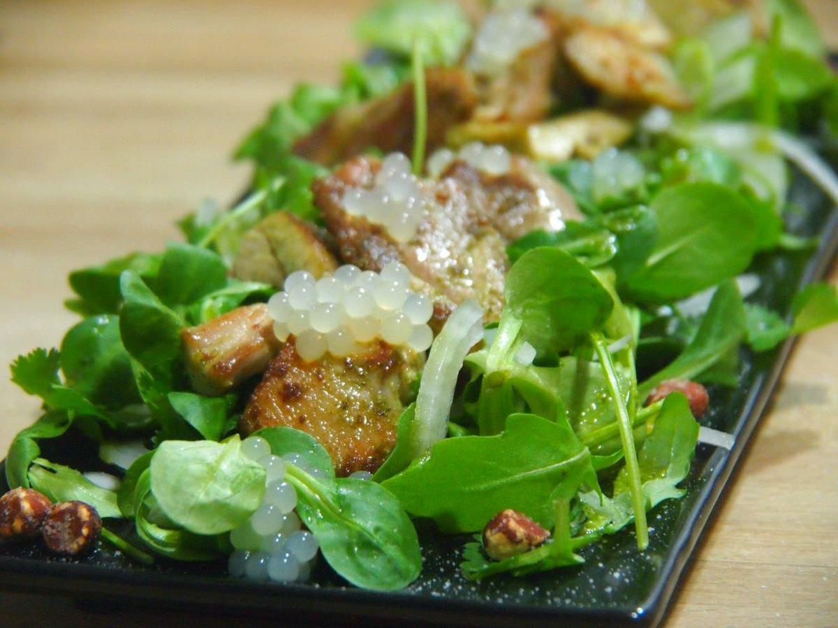 emplatado de Pollo con aliño verde y esferas de limón en ensalada