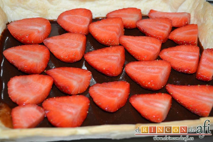 Tarta sorpresa de fresas y nata (crema de leche), lavar las fresas, cortarlas por la mitad e ir colocándolas sobre el chocolate