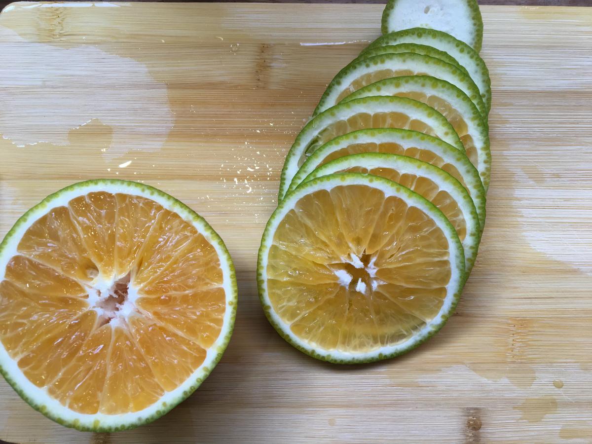 Naranja en tajadas en tabla de madera