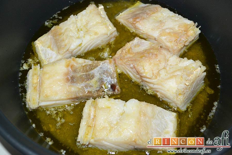 Pisto con bacalao y ajos tiernos, darle la vuelta al bacalao para que se terminen de confitar