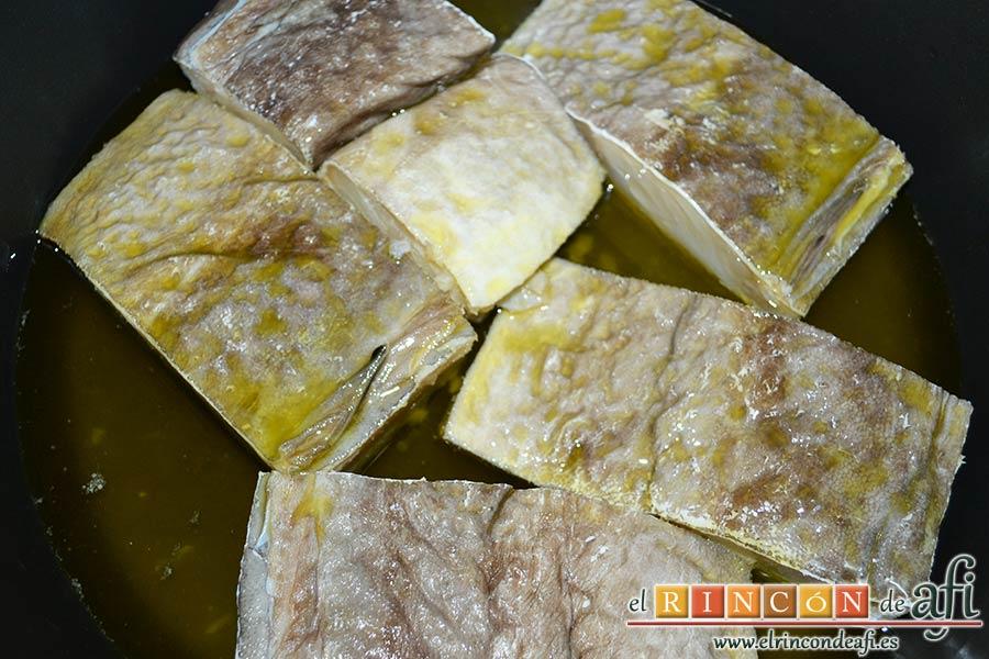 Pisto con bacalao y ajos tiernos, poner a confitar en un caldero con abuntante aceite de oliva a baja temperatura