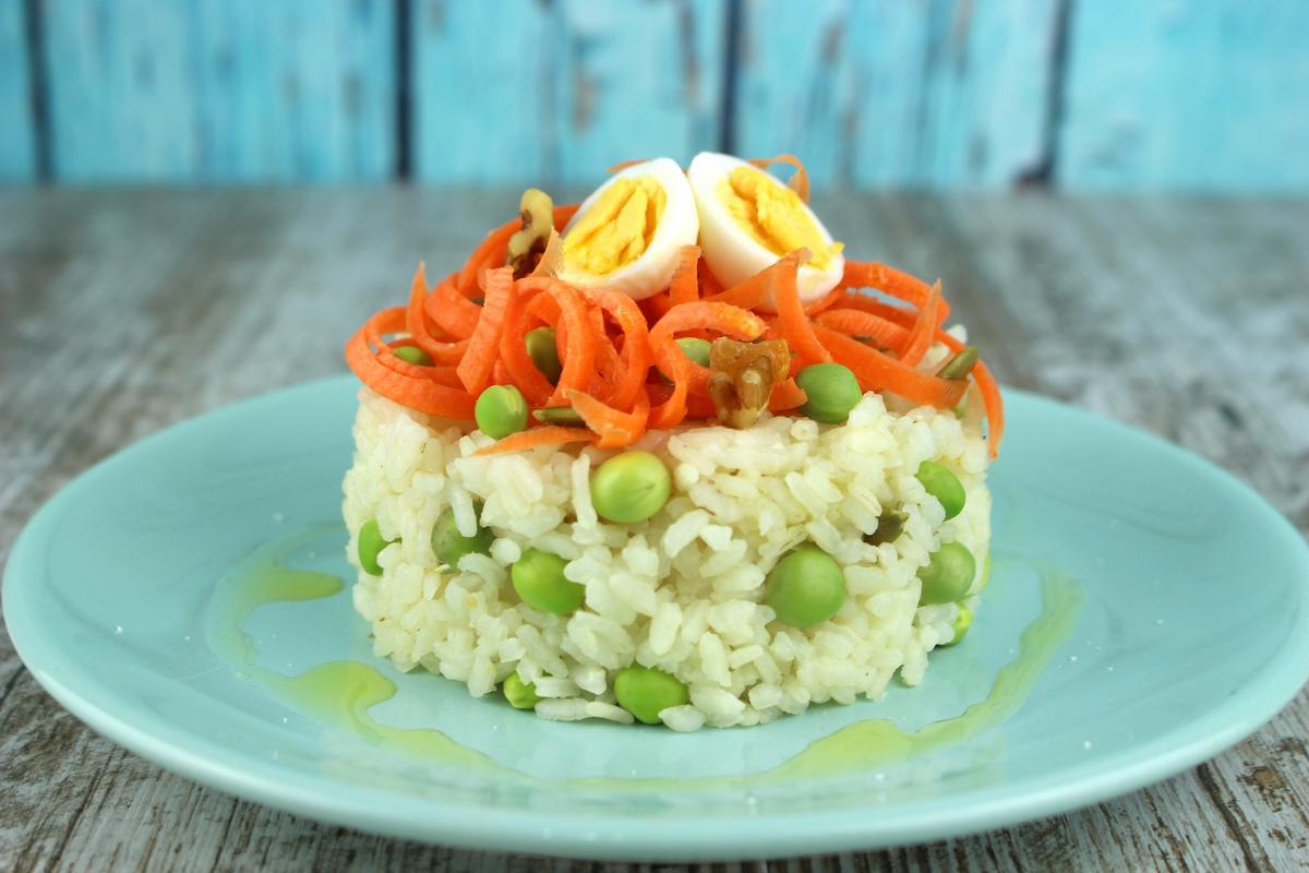 Ensalada de arroz con zanahorias, guisantes frescos y huevos de codorniz