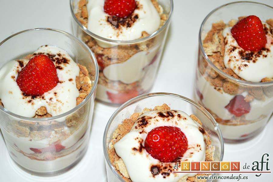 Tiramisú de fresas y amaretti, poner un poco más de crema, espolvorear con cacao en polvo y decorar con una fresa
