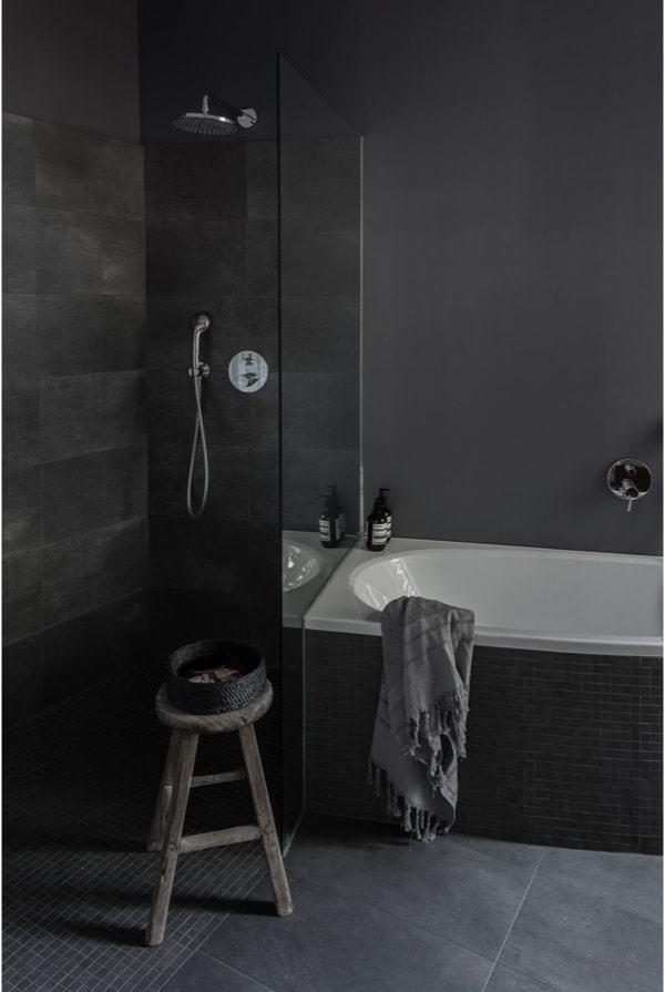 Zona de ducha y baño con tonos grises oscuros