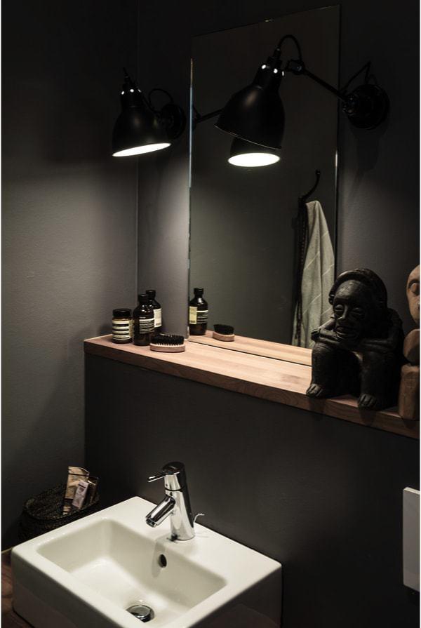 Baño con paredes muy oscuras, típico del estilo masculino