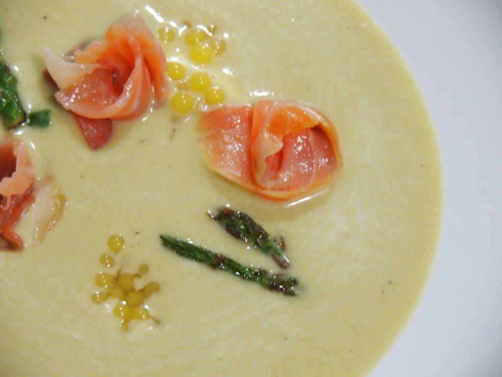 plato de crema de espárragos verdes con flores de salmón