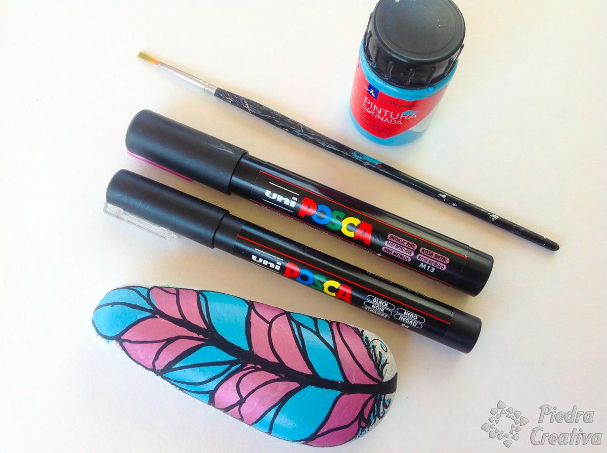 Manualidad de pluma pintada en piedra de rosa y azul