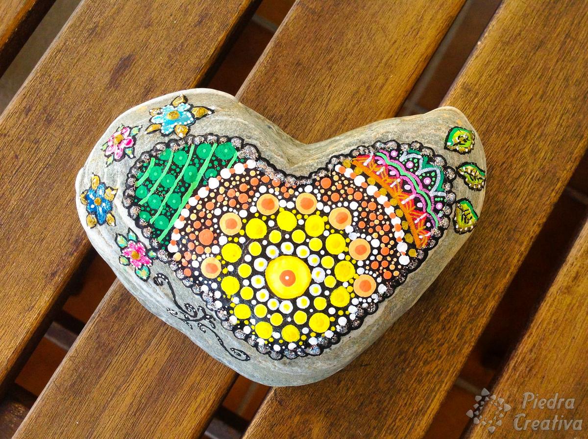 Mandala sobre piedra de corazón pintada