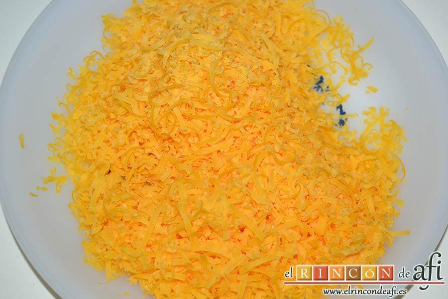 Pasta con ajo y queso Cheddar en una olla, rallar el queso Cheddar