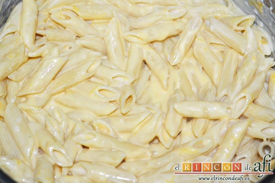 Pasta con ajo y queso Cheddar en una olla, remover bien