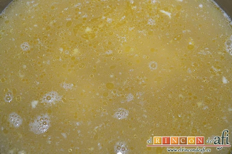 Pasta con ajo y queso Cheddar en una olla, echar el caldo