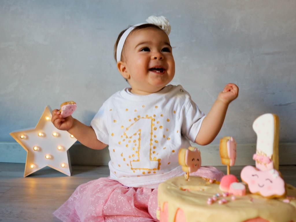 bebe riendo detras de una tarta