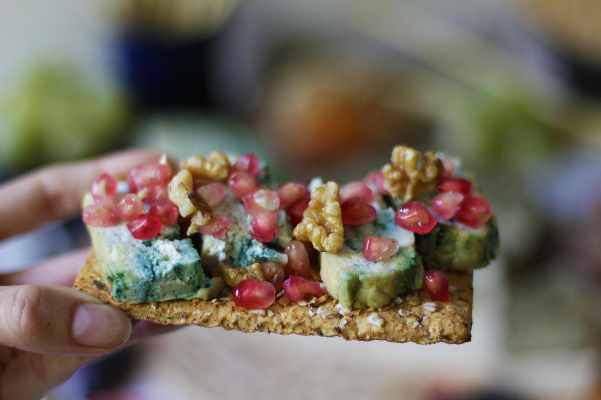 Tostada con queso crudivegano de anarcardos y espirulina con granada y nueces
