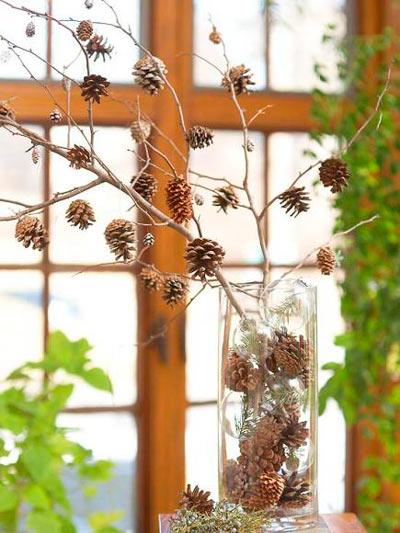 Centro navideño casero con ramas secas y piñas