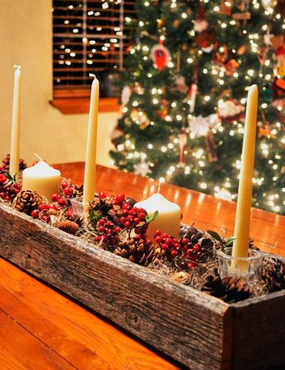 centro de mesa de madera con plantas de navidad y velas