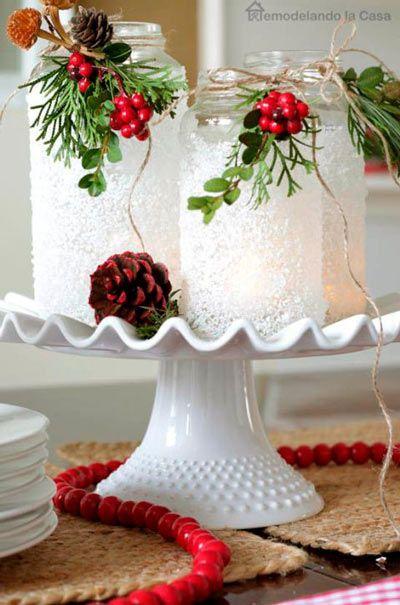 Manualidad de portavelas a partir de tarros de conservas con falsa nieve y muérdago