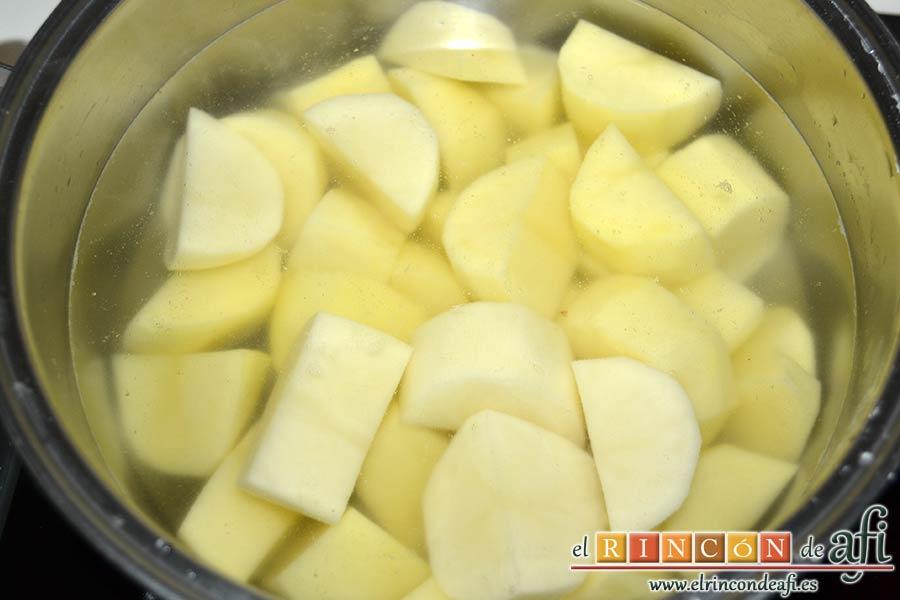 Pastel de bacalao, sancocharlas las papas en un caldero con agua
