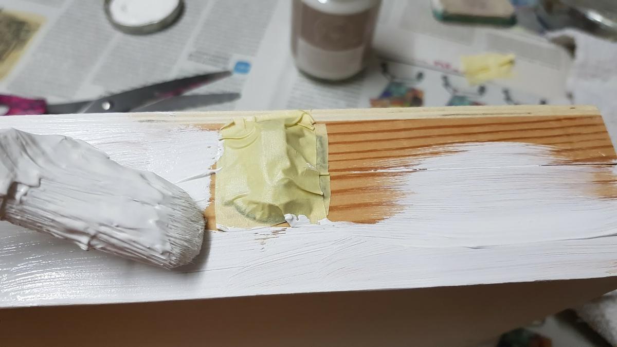 Vamos a darle una o dos capas de imprimación a la cajita, para que agarre bien la pintura. Para ello, primero cubrimos los cierres de metal con cinta de pintor, para no mancharlos. Es importante que antes de pintar, se pase una lija de grano fino por toda la superficie, para eliminar cualquier astilla o imperfección.