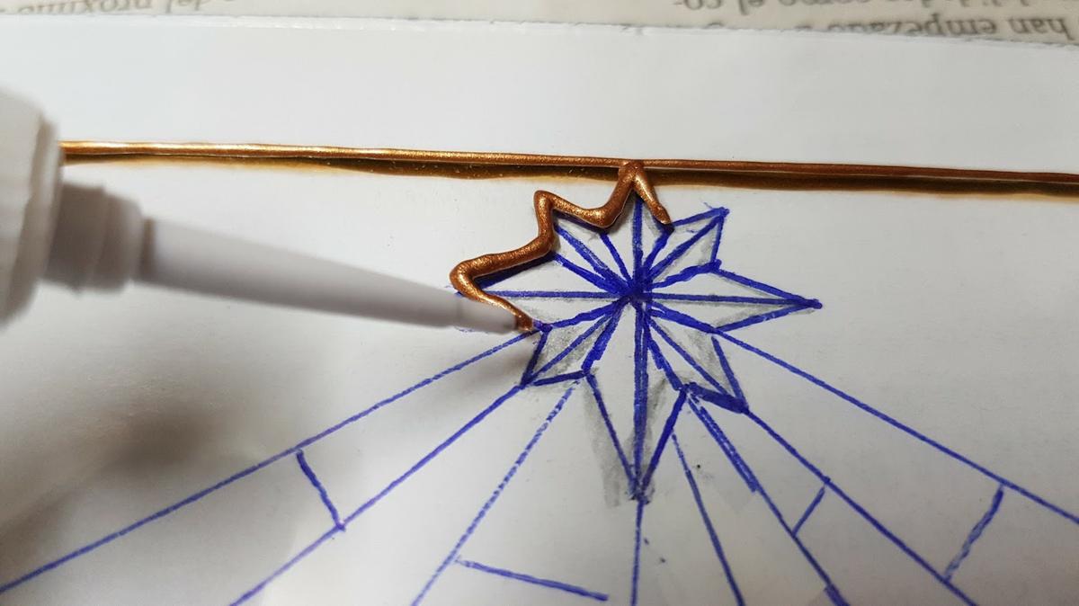 Una vez tenemos claro el diseño que queremos representar en la cajita, lo dibujamos en un papel y después lo pegamos con celo al cristal, para que no se mueva. Ahora comenzamos a delinear los contornos con el plomo líquido.