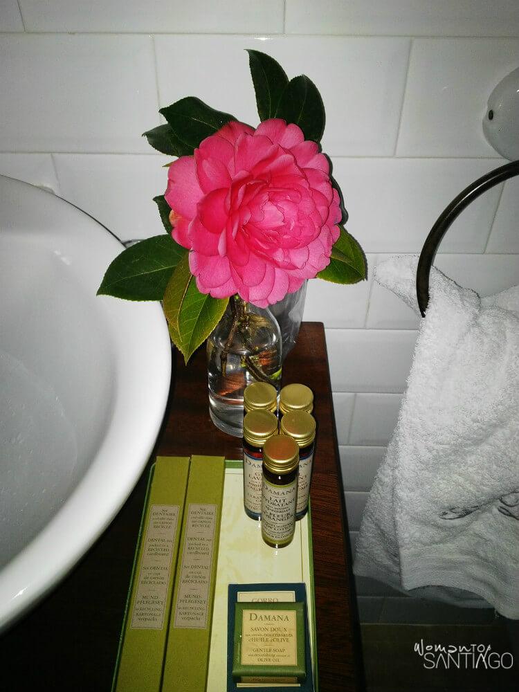 detalle de flor en el baño juntos a amenities