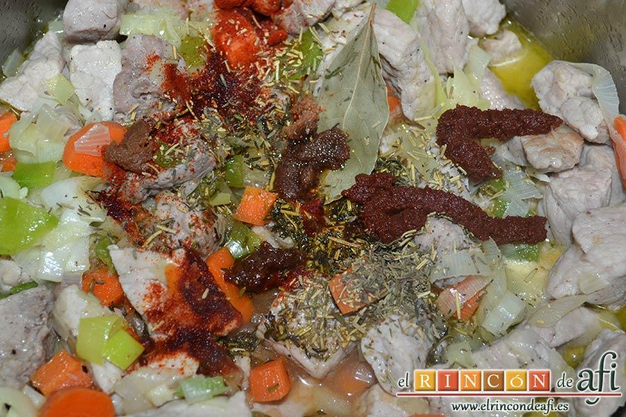 Magro de cerdo estofado, añadir la hoja de laurel, la pastilla de caldo de carne troceada, las cucharaditas de tomillo, romero y pimentón dulce y las 2 cucharadas de concentrado de tomate