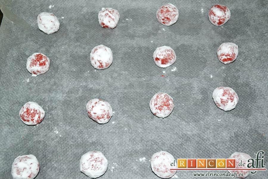 Red Velvet Cookies, rebozar las bolitas en azúcar glass y colocarlas sobre una bandeja de horno