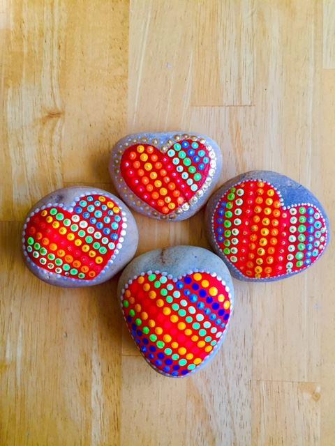 Corazones de colores en piedras pintadas