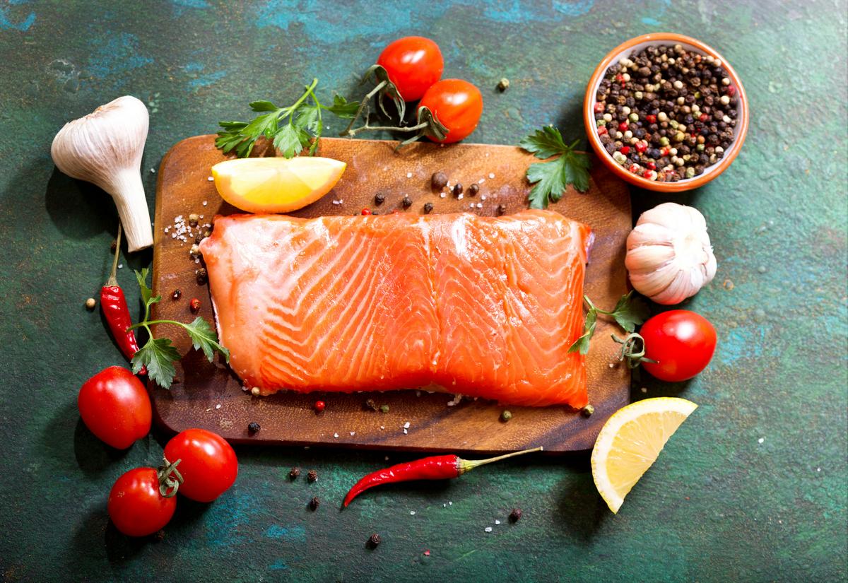 fresh salmon with vegetables on wooden board