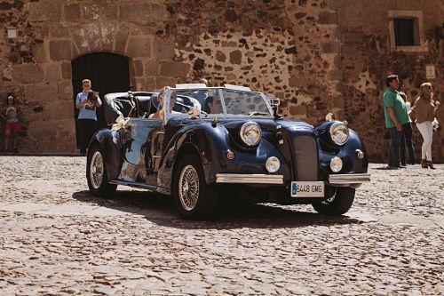 Recién casados conduciendo coche clásico