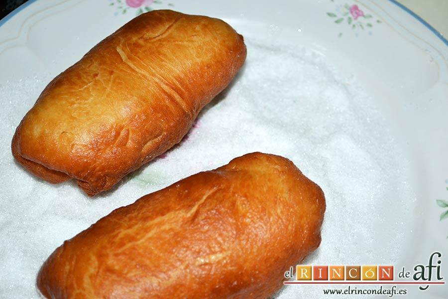 Xuxos rellenos de crema pastelera, una vez fríos pasarlos a un plato con azúcar blanquilla