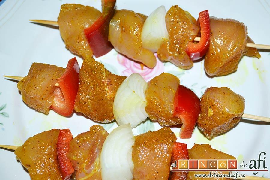 Brochetas de pechuga de pollo marinadas al curry con cebollas y pimientos, insertar en las brochetas alternando ingredientes