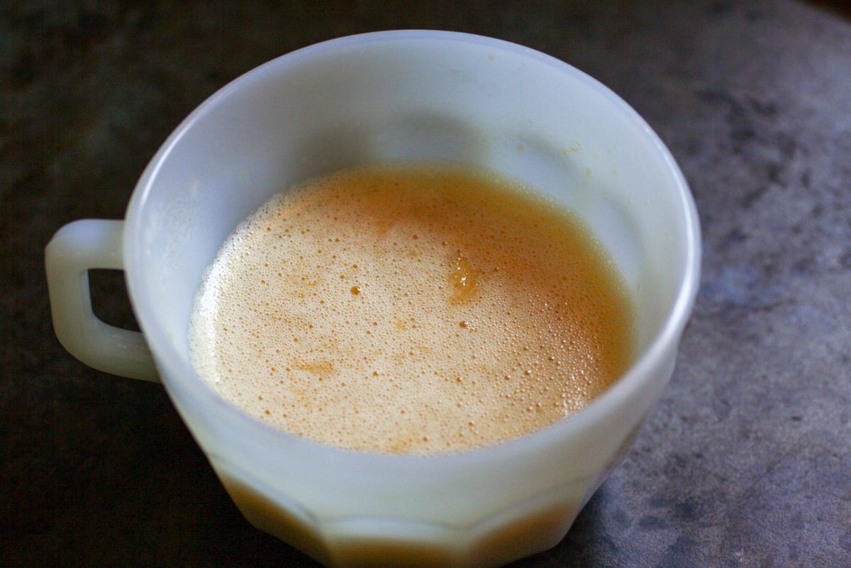 taza blanca sobre una fuente para horno, con masa para torta